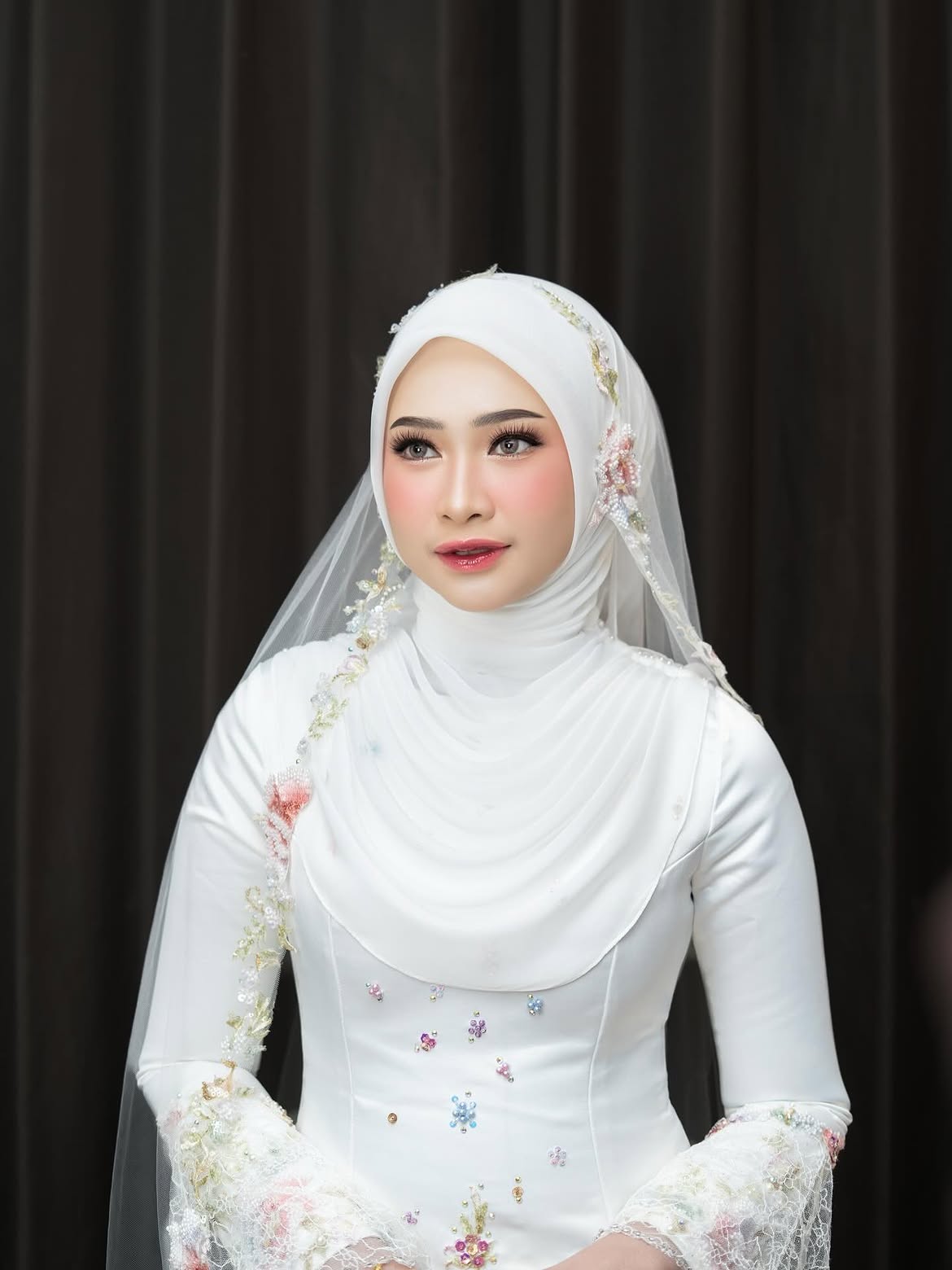 Rias pernikahan bernuansa putih dengan hijab bordir bunga dan veil, riasan flawless glam