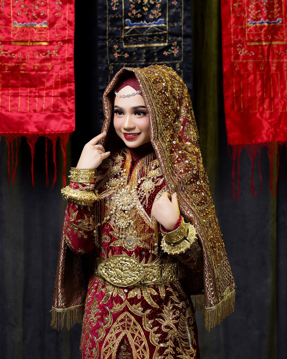 Rias busana adat pengantin merah marun dan emas, lengkap dengan aksesori tradisional
